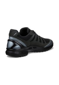 Chaussure de sport noire avec tissu en mesh, semelle en caoutchouc texturée, accents réfléchissants et support rembourré au niveau de la cheville.