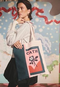 Drobės pirkinių maišelis su gėlių raštu rožinės, žalios ir juodos spalvų derinyje. Turi tvirtas rankenas ir spalvų blokų raštą.