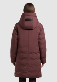 Bordo puffer jakk, millel on suur kapuuts, nahast logopriimula, tõmblukuga taskud ja põlvedeni ulatuv disain, millel on sile tekstuur.