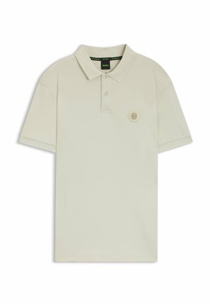 Beige polo shirt with a textured collar, two-button placket, and hexagonal logo on the chest. Short sleeves and soft cotton material.