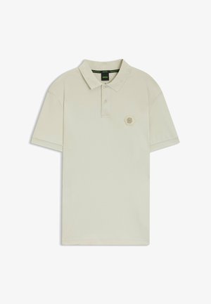 Beige polo-shirt med struktureret krave, to-knaps lukning og sekskantet logo på brystet. Korte ærmer og blødt bomuldsstof.