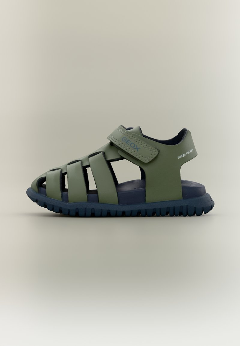Žalios spalvos sandalai su orui pralaidžia konstrukcija, plačiomis juostomis ir Velcro užsegimu. Guminė pado dalis su tekstūruotu paviršiumi geram sukibimui. Tinka naudoti vandenyje.