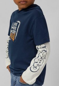 Granatowy hoodie z krótkim rękawem i białymi długimi rękawami z graficznym napisem. Wykonany z miękkiej bawełny, ma luźny krój i regulowany kaptur.