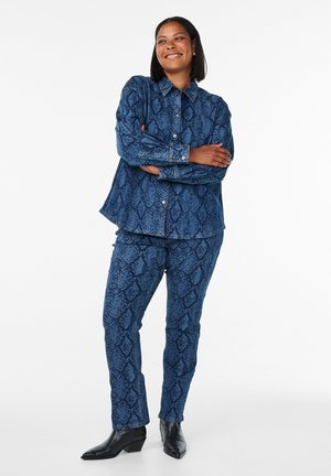 Set di camicia e pantaloni in denim blu con una stampa a serpente. La camicia presenta un colletto e bottoni, mentre i pantaloni hanno una vestibilità slim.