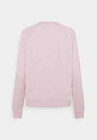 Ljusrosa sweatshirt, tillverkad av mjukt tyg, har rund halsringning, raglanärmar samt ribbade muddar och fåll för extra textur.