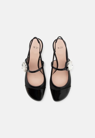 Črne patentne usnjene slingback čevlje z zaobljenim prstom, dekorativnim kristalnim poudarkom na zunanji strani in minimalističnim dizajnom trakov.