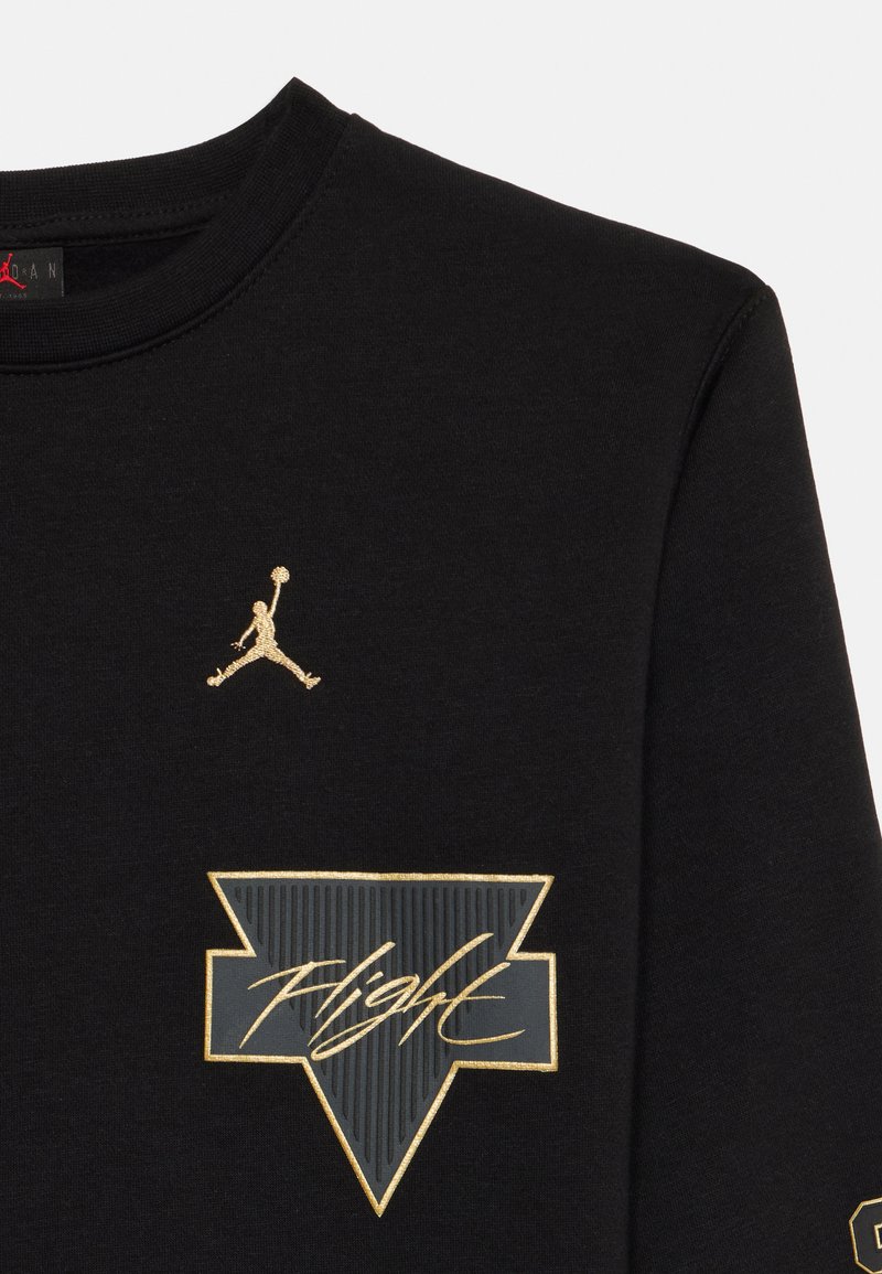 Schwarz langärmliges Jersey mit goldfarbenem Jumpman-Logo und "Flight"-Grafik in Gold und Schwarz, mit geripptem Hals- und Armabschluss.
