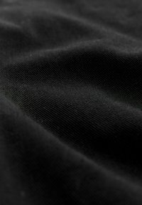 Schwarzer Stoff mit einer glatten, leicht strukturierten Oberfläche. Das Material zeigt subtile Falten und hat eine einheitliche Farbe ohne Muster.