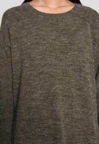 Maglione a maglia verde oliva con scollo rotondo, maniche lunghe e un tessuto morbido e testurizzato. Variazioni di colore sottili. Design casual.