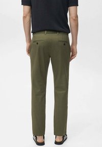 Olive green chinos with a straight fit, featuring two back pockets and a smooth texture, paired with flat sandals.
