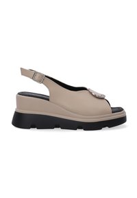 Beige slingback sandalen met een soepele leren bovenkant, ronde neus, gespsluiting en zwarte chunky zool. Bevat een decoratieve metalen acccent.