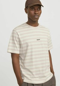 Camiseta de rayas en color beige claro y crema, hecha de algodón. Presenta mangas cortas y un escote redondo, con un pequeño logo de "Originals" en la parte frontal.