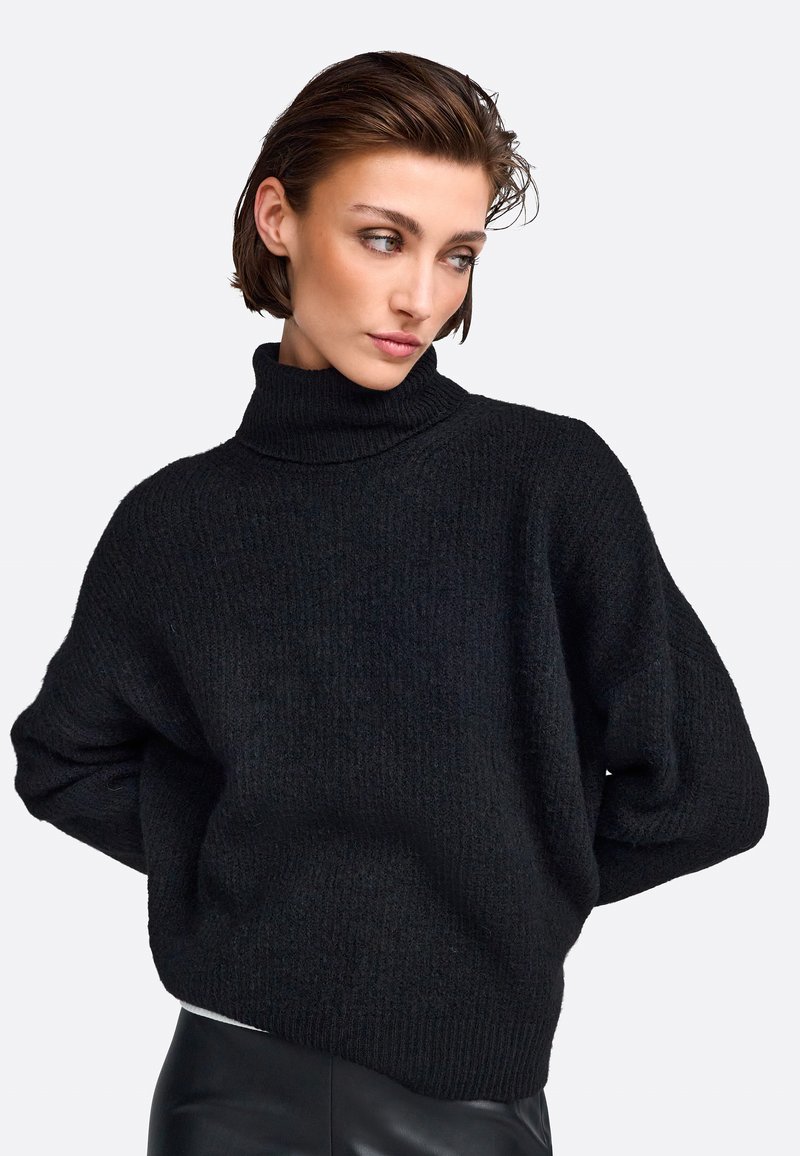 Schwarzer Rollkragenpullover mit grob gestrickter Textur, fallenden Ärmeln sowie gerippten Bündchen und Saum. Der lässige Schnitt sorgt für zusätzlichen Komfort und Wärme.