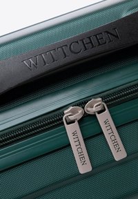 Valigia rigida verde con superficie texture, maniglia superiore nera e zip argentate con il marchio "WITTCHEN".