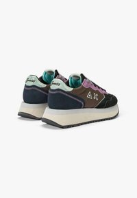 Scarpe sportive con un mix di suede nero, marrone e viola e tessuto, caratterizzate da una robusta suola bianca e dettagli con logo astratto.