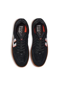 Svarta mockaskor för träning med gummisulor, vita och orange detaljer, rundad form och en vadderad tunga med snörning.