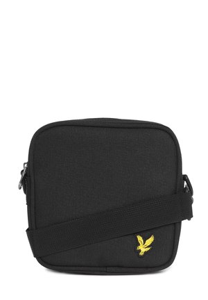 Mała czarna torebka na ramię z tkaniny z regulowanym paskiem i żółtym haftowanym logo ptaka na przodzie.