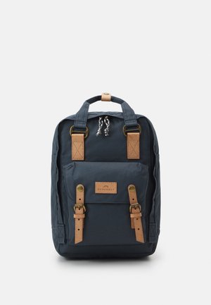 Tengerészkék textil hátizsák barna bőr kiegészítőkkel, elülső pántokkal és felső fogantyúval. Zsinóros záródással és márkajelzéssel rendelkezik.