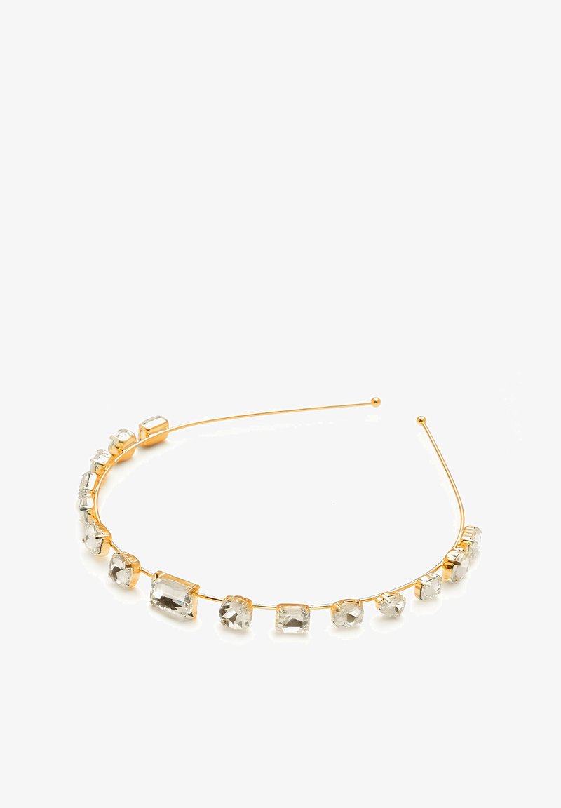 Goldfarbene Haarband mit klaren, geometrisch geschliffenen Kristallen in linearer Anordnung. Glattes Metalldraht mit abgerundeten Enden für einen sicheren Sitz.