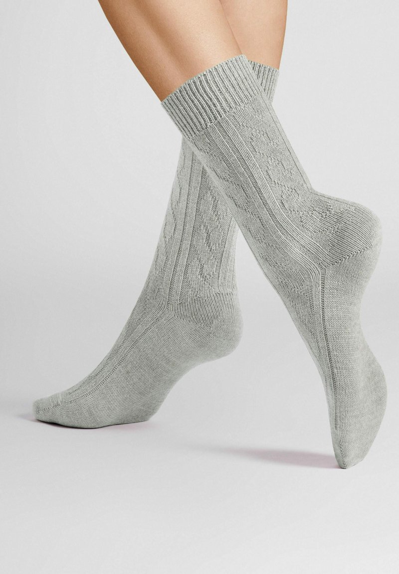 Graue gestrickte Socken mit einem gerippten Bündchen und strukturiertem Muster. Das Material wirkt weich und dehnbar, geeignet für Komfort und Wärme.