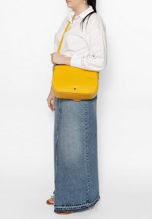 Geel lederen schoudertas met een rechthoekige vorm, een platte klep en een lange verstelbare schouderriem, gepositioneerd op de heup.