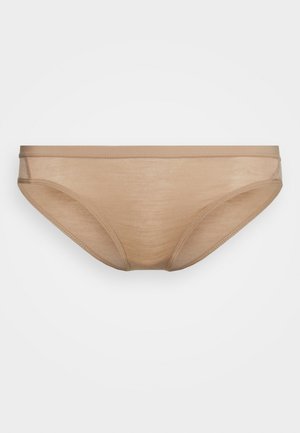 Culottes beige sans coutures fabriquées à partir d'un tissu doux et léger. Elles présentent une taille basse et un fin élastique pour un ajustement lisse.