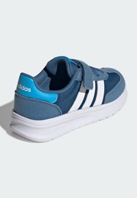 Modrá športová obuv s bielymi pruhmi, suchý zips, polstrovaný golier, podrážka Cloudfoam a textilný zvršok.