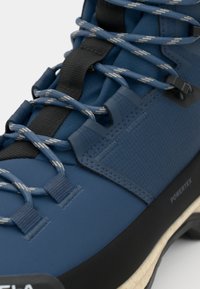 Zils pārgājienu zābaks no teksturēta materiāla ar melniem akcentiem. Ir rakstainas šņorītes un pastiprināta purngala daļa ar uzrakstu “POWEREX”.