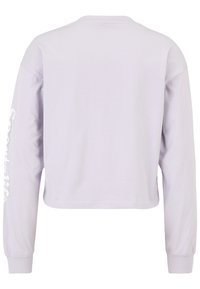 Vaalean lilac pitkähihaisen lyhyen paidan. Pehmeä kangas, pyöreä pääntie ja painatettua tekstiä vasemmassa hihassa. Sujuva pinta.