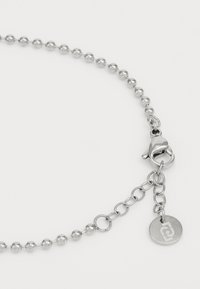 Collana in argento con perle tonde, chiusura a moschettone e un estensore regolabile con un dettaglio in forma di pendente circolare.