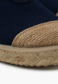 Espadrille in tela navy con punta in juta intrecciata e suola in fibra naturale testurizzata, caratterizzata da un design pulito e minimalista.