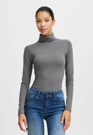 Grijze lange mouwen turtleneck top van zacht, rekbaar materiaal, gedragen met blauwe denim jeans met een klassieke snit en subtiele vervaging.
