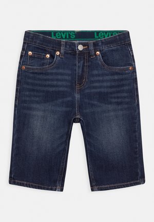 Pantalones cortos de mezclilla azul oscuro con corte recto, cinco bolsillos, remaches de cobre y una cinturilla con el logo verde de Levi's. Textura suave.