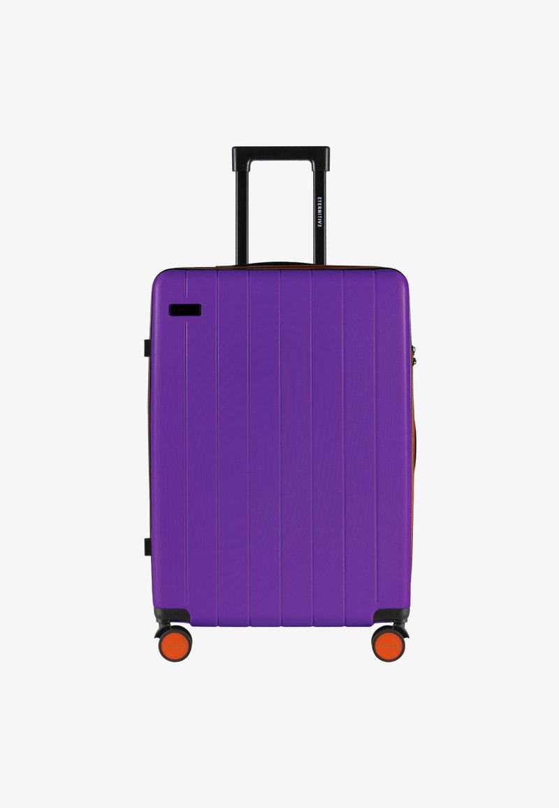 Fioletowa, twarda walizka z pionowymi rowkami, składanym czarnym uchwytem i pomarańczowymi kołami akcentującymi. Zamek błyskawiczny z boczną kieszenią.