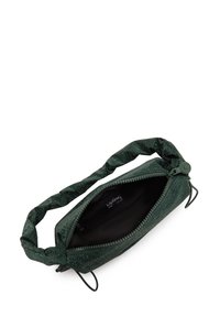 Borsa di stoffa verde con finitura texturizzata, chiusura a zip e manico intrecciato. L'interno è nero con un'etichetta del produttore visibile.