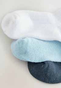Trois paires de chaussettes : une blanche, une bleu clair et une bleu foncé. Fabriquées dans un matériau doux avec une texture côtelée. Design lisse.