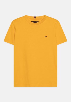 Żółta koszulka z krótkim rękawem wykonana z bawełny, z okrągłym dekoltem i małym logo na piersi. Gładka faktura.