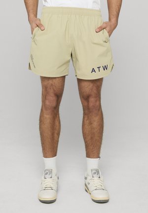 Beige badeshorts med elastisk linning, sidelommer og trykt "ATW" i marineblå. Letvægtsmateriale med blød tekstur designet for komfort.