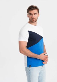 Tričko s krátkým rukávem s barevným blokovým designem v bílé, námořnické modři a modré. Vyrobeno z bavlny, s dvojitým diagonálním vzorem.