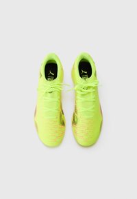 Neon żółte buty sportowe z teksturowanej tkaniny, kontrastującymi różowymi akcentami, okrągłymi sznurówkami i eleganckim, opływowym kształtem.