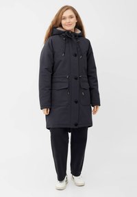Tmavě modrá nepromokavá parka s kapucí lemovanou kožešinou, patentkami, nastavitelnými šňůrkami a předními kapsami; měkká textura a délka ke kolenům.