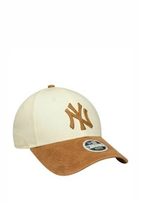Creme-beige Kappe mit einem braunen Wildleder-Schirm, die ein gesticktes NY-Logo in passendem Braun zeigt. Unter dem Logo ist ein schwarzes New Era-Tag sichtbar.
