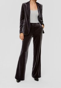 Velvet suit in dark gray featuring a tailored blazer with notch lapels and flared trousers. The material has a soft, rich texture.