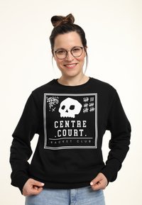 Černá mikina s bílou grafikou znázorňující lebku a textem "CENTRE COURT. RACKET CLUB." Ribbed cuffs a lem, měkká textura.