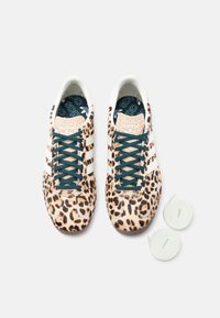Αθλητικά παπούτσια με λεοπάρ σχέδιο, λευκές ρίγες, κορδόνια τιρκουάζ, υφασμένο μπροστινό μέρος και δύο επιπλέον λευκά κορδόνια σε ανοιχτό φόντο.