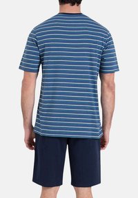 T-shirt à manches courtes rayé dans des tons de bleu avec des largeurs variées, associé à un short marine. Mélange de coton, design décontracté, col rond.
