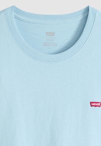 T-shirt Levi's bleu clair avec col rond et petit logo rouge Levi's sur le côté gauche de la poitrine.