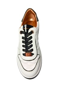 Witte leren sneaker met een gequiltte textuur, zwarte veters en glanzende zwarte accenten. Bevat een bronzen hardware detail en een interieur in koper.
