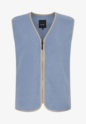 Šviesiai mėlynas vilnos liemenė, su tekstūruotu paviršiumi, smėlio spalvos apdaila ir priekiniais užtrauktuku. Be rankovių dizainas su V formos iškirpte.