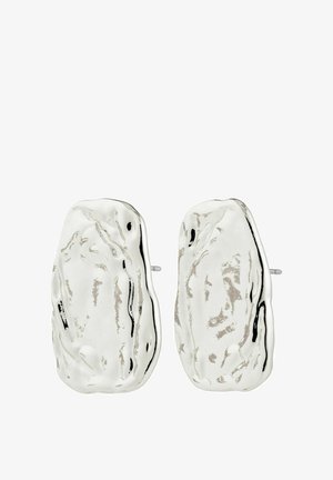 Abstrakti formas sudraba metāla studu auskari ar nedaudz teksturētu un neregulāru virsmu.